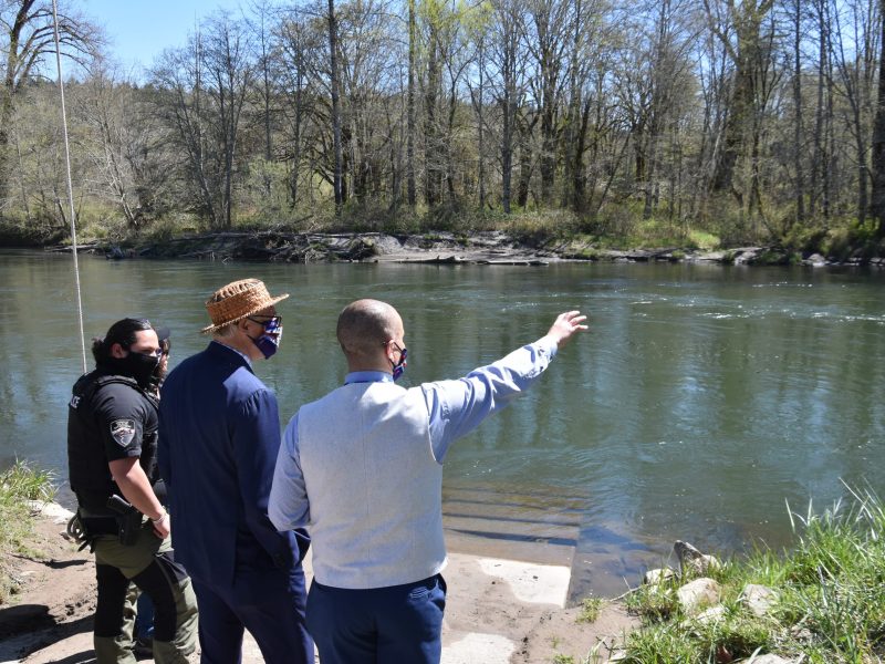 Gov. Jay Inslee looks over a river near the Wa He Lut Indian School in April 2021.