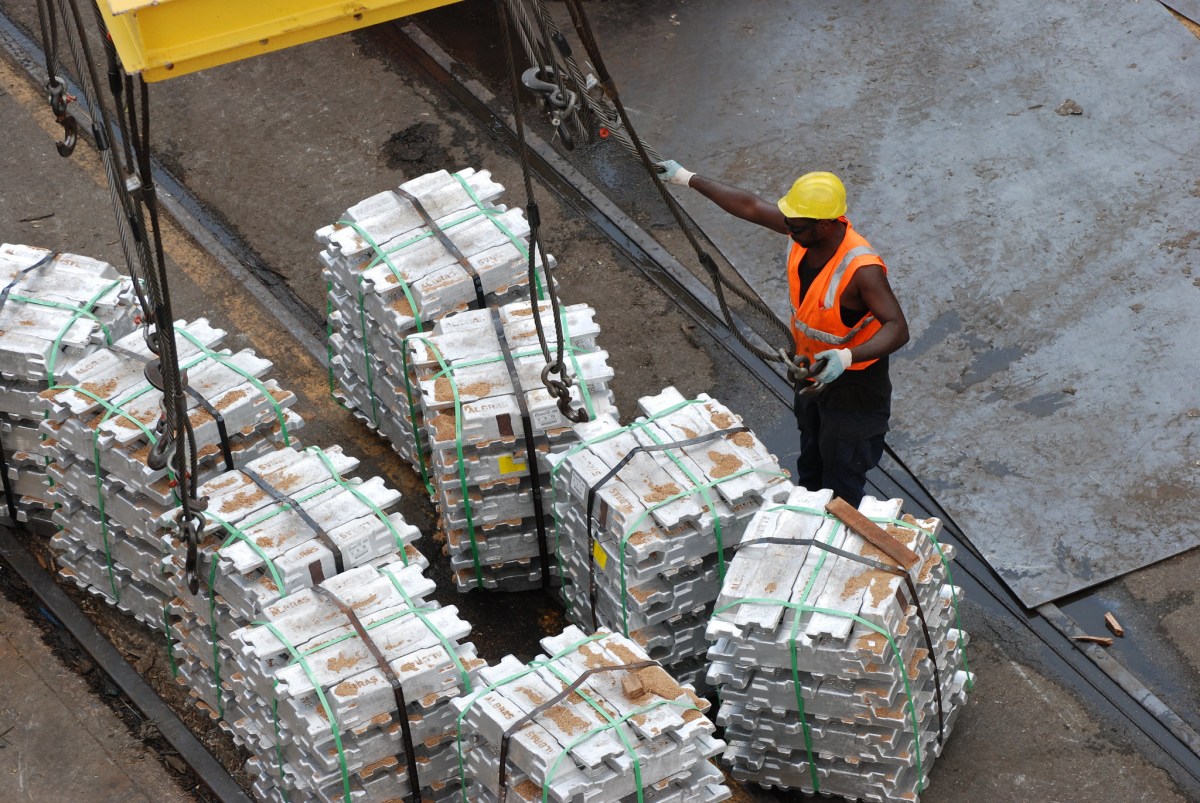 A longshoreman unloads aluminum ingots.