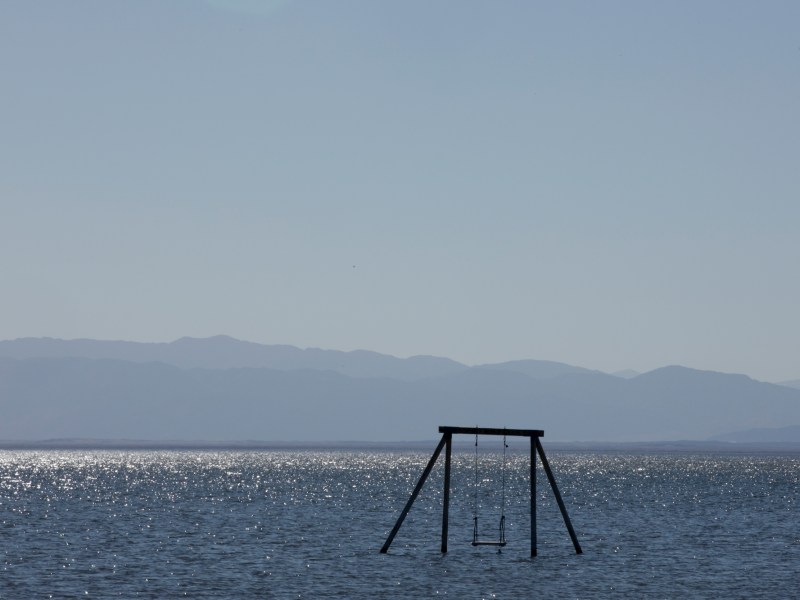 A swing set stands alone in the Salton Sea.