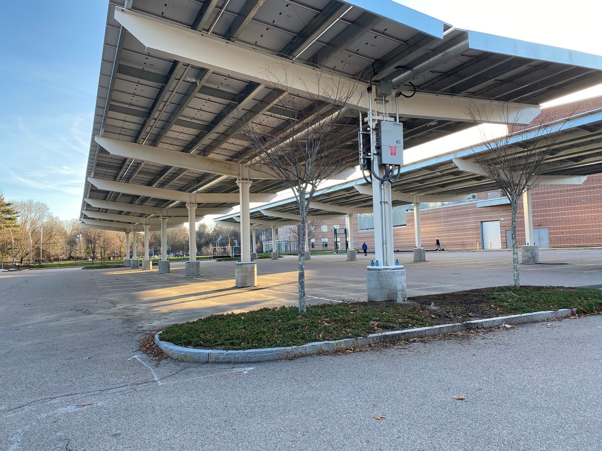 Solar panels suspended over a school parking lot.