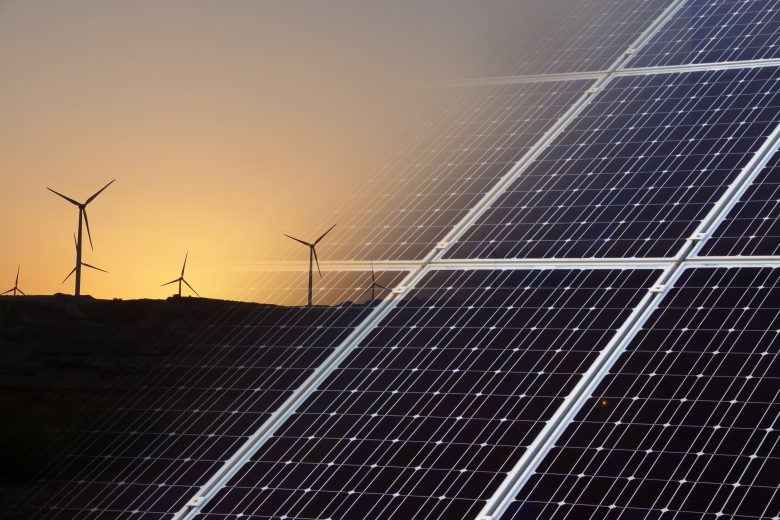 An image of wind turbines and one of solar panels superimposed into each other.