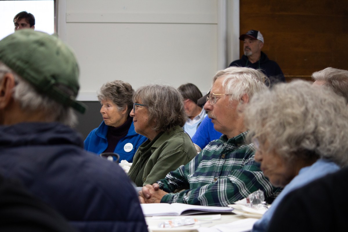 People with concerned faces at a public meeting.