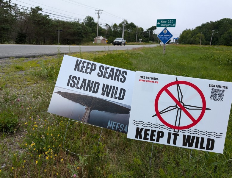 Signs bearing the names of groups opposed to offshore wind are posted at the turnoff from Route 1 to Sears Island, Maine, on July 5.